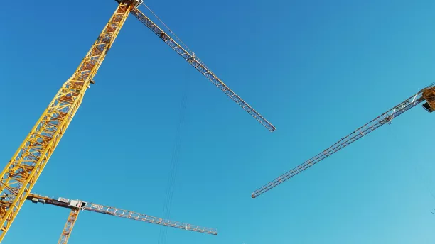 Kräne stehen für die Umsetzung von Planungen. Im Vorfeld sollten Zielkonflikte im Bereich Luftschadstoffimmissionen und Lokalklima geklärt sein.